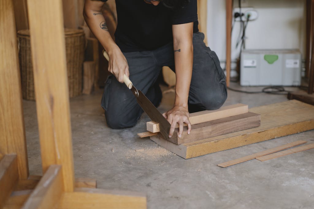 Crop man cutting wood in workshop